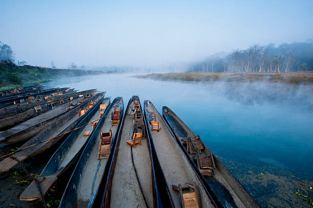 Boats on a misty river at sunrise.