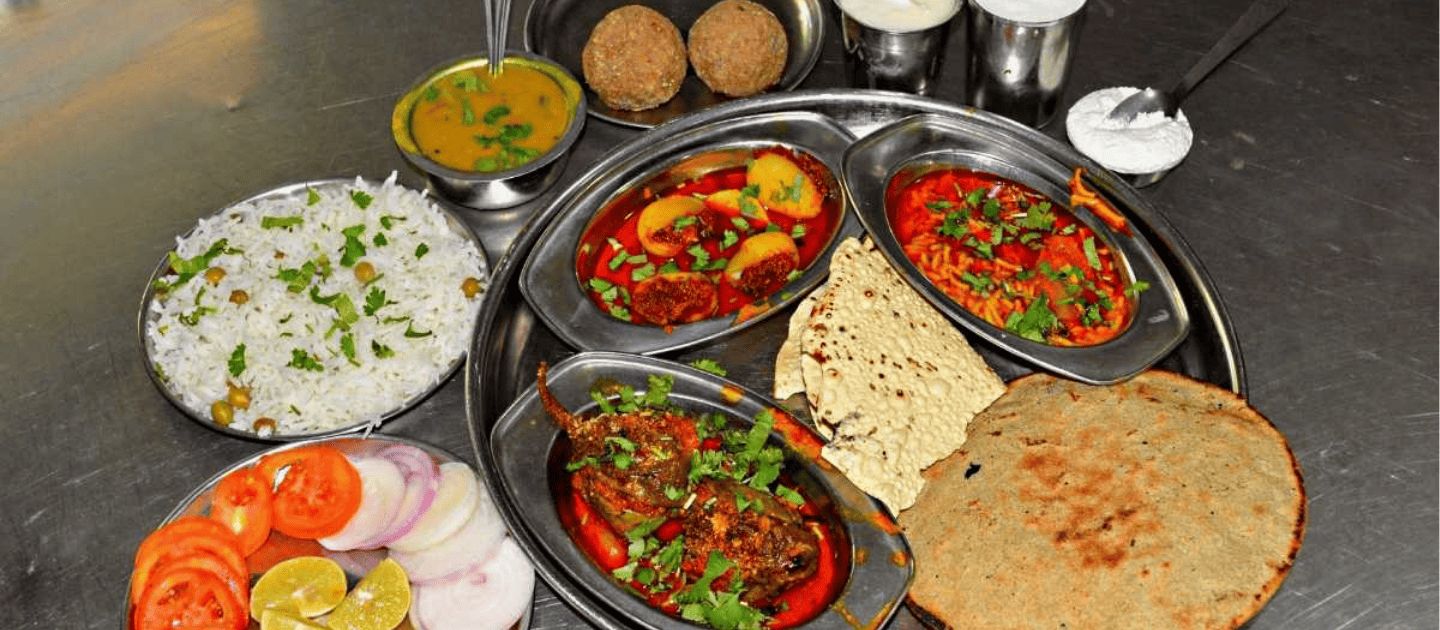 A traditional Assamese thali featuring Masor Tenga, a popular fish curry.