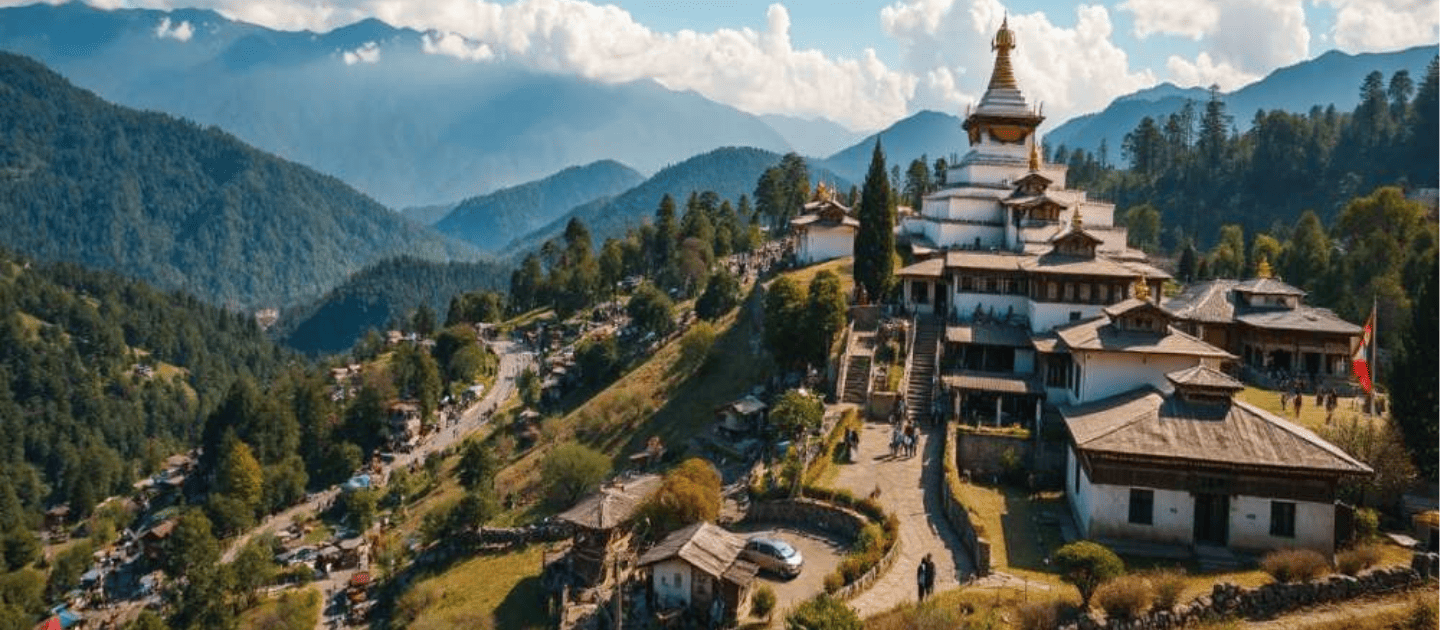 Scenic view of the majestic Tawang Monastery perched on a hillside, featuring traditional Buddhist architecture with white walls and golden roofs against a backdrop of blue mountains and green valleys