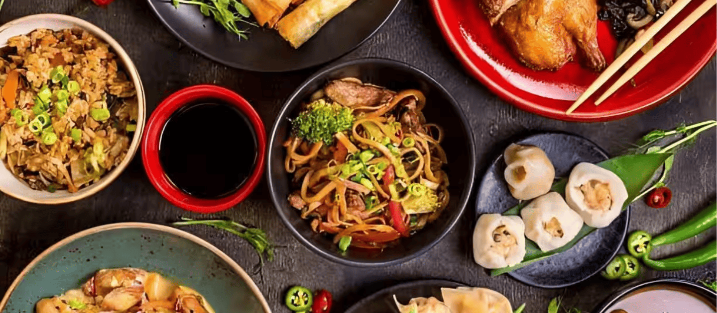 Delicious spread of authentic Himalayan cuisine featuring steamed momos, stir-fried vegetable noodles, fried rice, and roast chicken, representing the rich food culture of Kalimpong