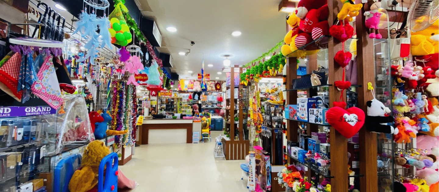 Interior of a vibrant gift shop in Thanjavur filled with colorful plush toys, hanging decorations, and souvenirs, representing the modern shopping options in the city