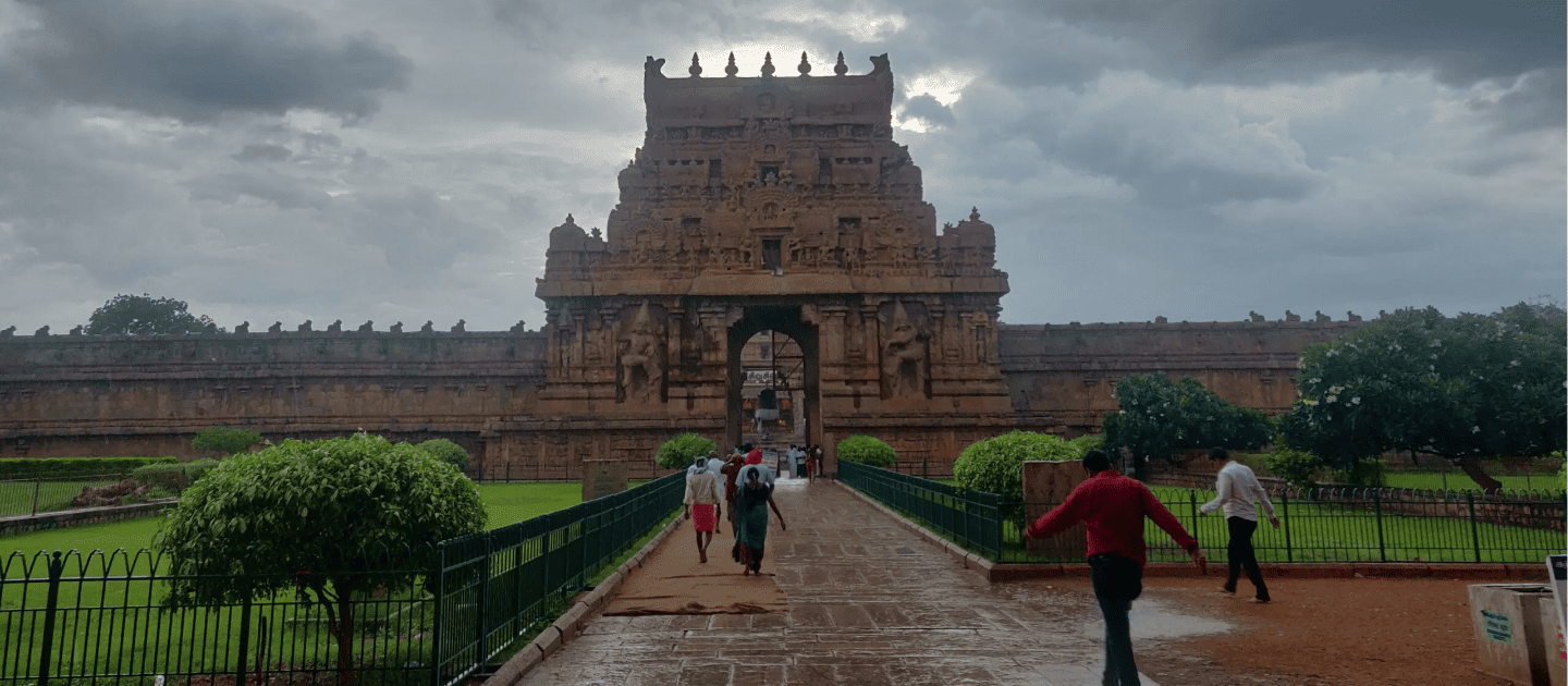 Majestic entrance tower (Gopuram) of the UNESCO World Heritage Brihadeeswarar Temple in Thanjavur, showcasing intricate Chola architecture under a cloudy sky