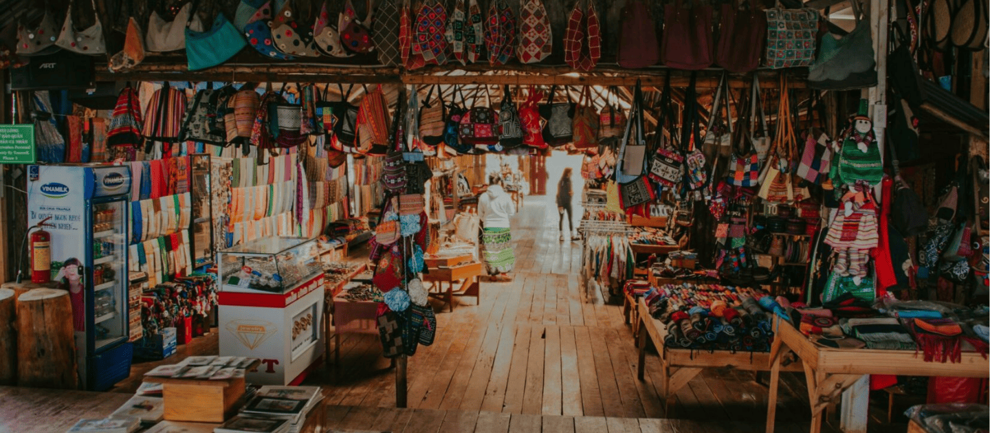 Rustic souvenir shop in Andaman filled with colorful handmade tote bags, hanging textiles, and island handicrafts, representing the vibrant local shopping experience