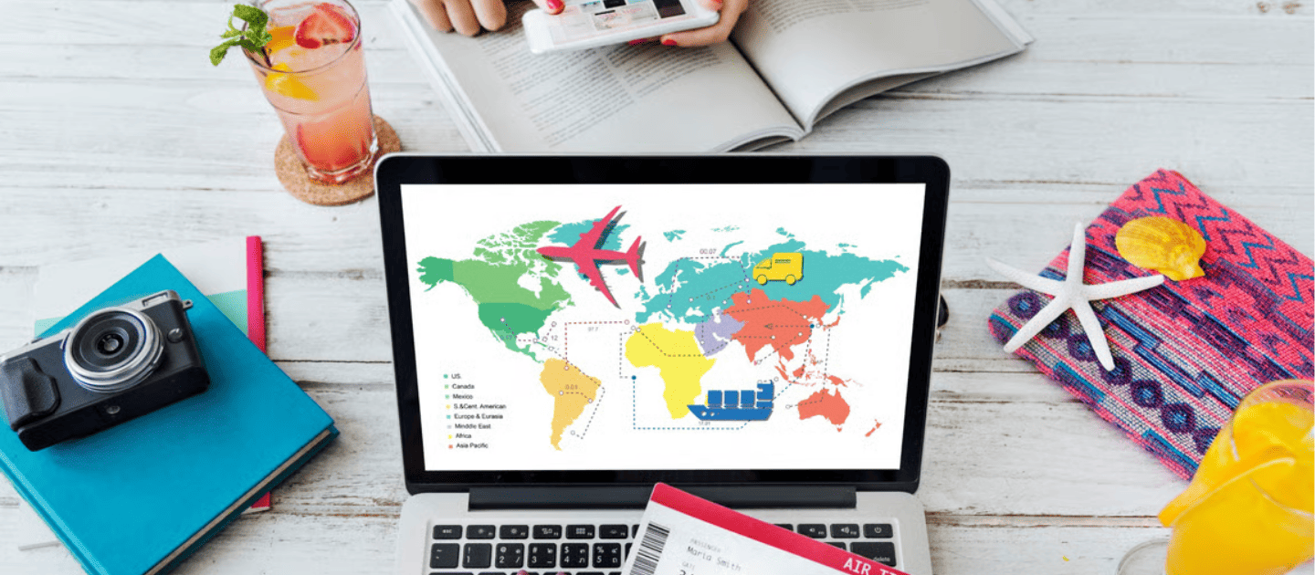 Travel planning workspace featuring a laptop displaying a world map with flight routes, a camera, passports, and a tropical drink, representing smart trip organization with TravellingLark