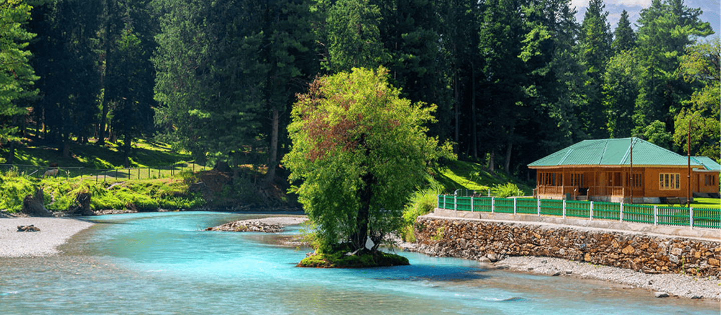 Picturesque view of the turquoise Lidder River flowing through Betaab Valley in Pahalgam, Kashmir, featuring a riverside cottage surrounded by pine forests