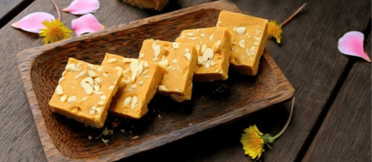 Traditional Patisa sweet dish garnished with almonds and served on a rustic wooden platter, a popular flaky dessert enjoyed in Patnitop and Jammu region