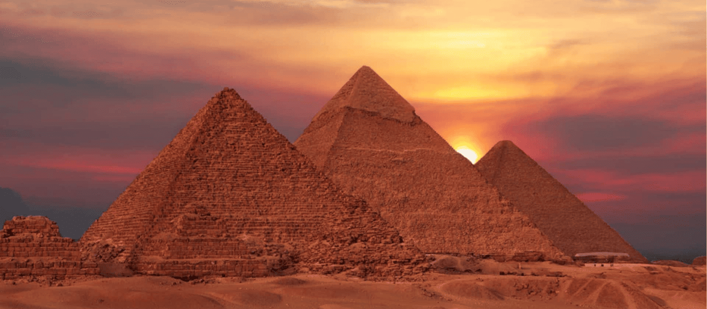 Stunning view of the Great Pyramids of Giza in Egypt silhouetted against a vibrant sunset