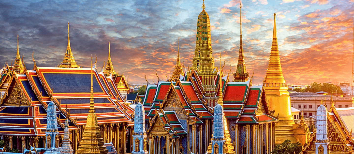 Majestic golden spires and ornate architecture of the Grand Palace and Wat Phra Kaew in Bangkok, Thailand at sunset