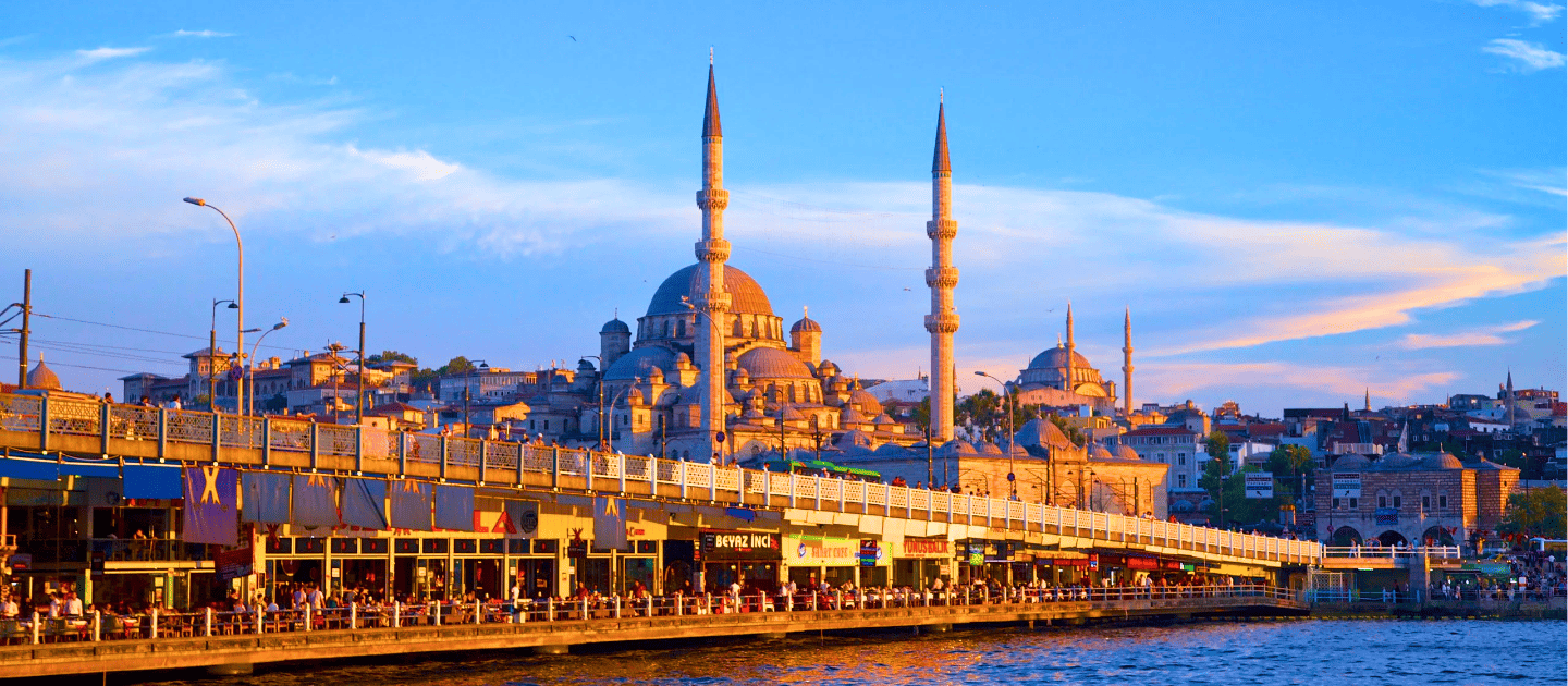 Scenic sunset view of the New Mosque and Galata Bridge in Istanbul, Turkey, overlooking the Golden Horn