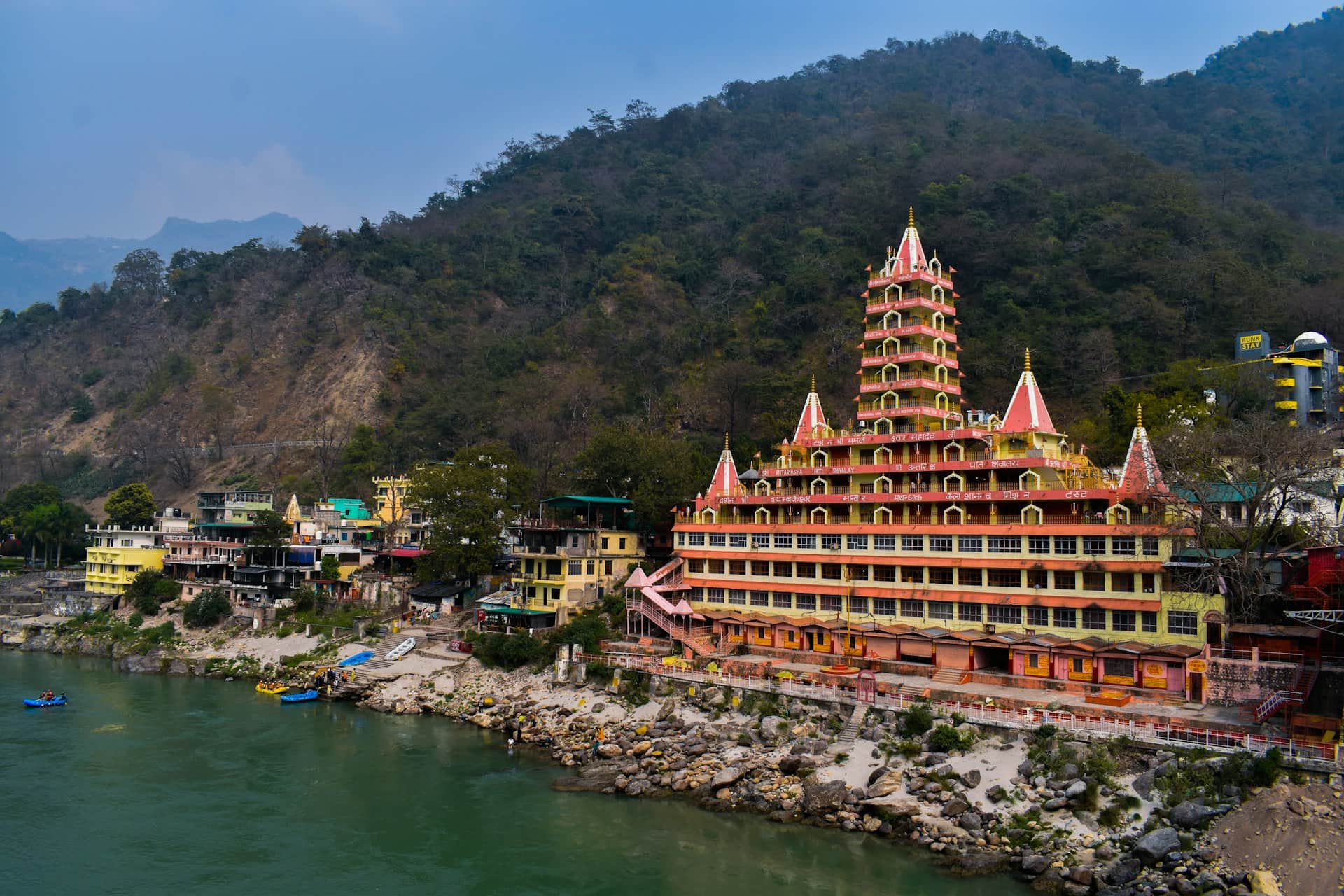 Temple complex by the riverside with hills in the background in Rishikesh, India Temple complex by the riverside with hills in the background in Rishikesh, India